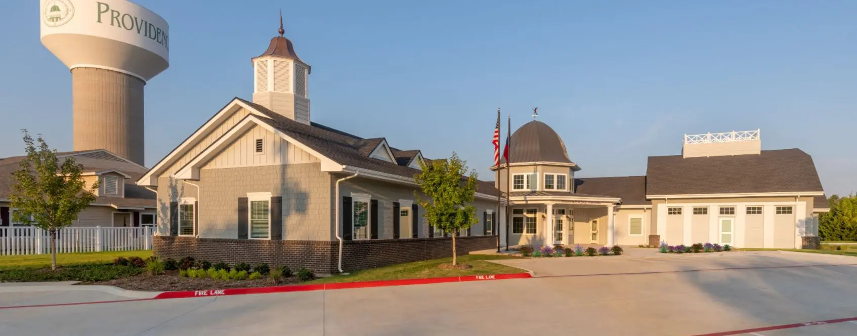 Gray L-shaped building with dark brown roof shingles