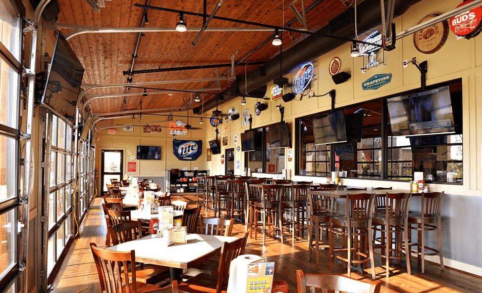 Interior of a Pluckers restaurant with all the neon signs and TVs turned on during the day