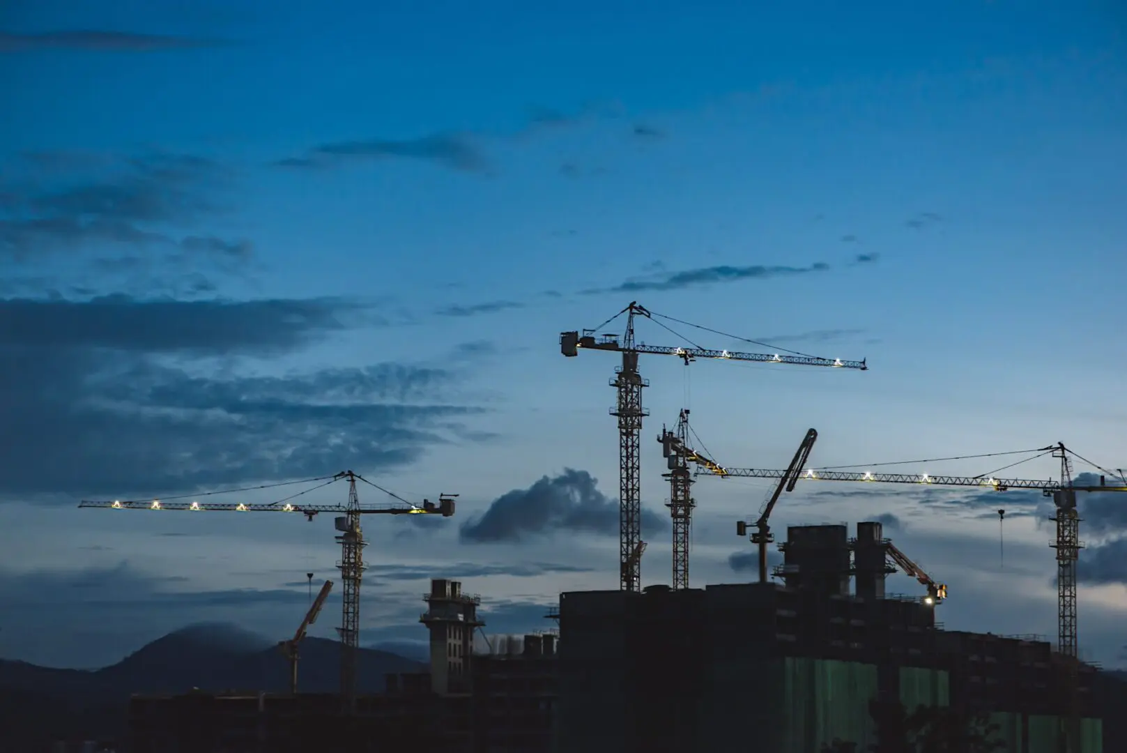 construction cranes working on an unfinished building